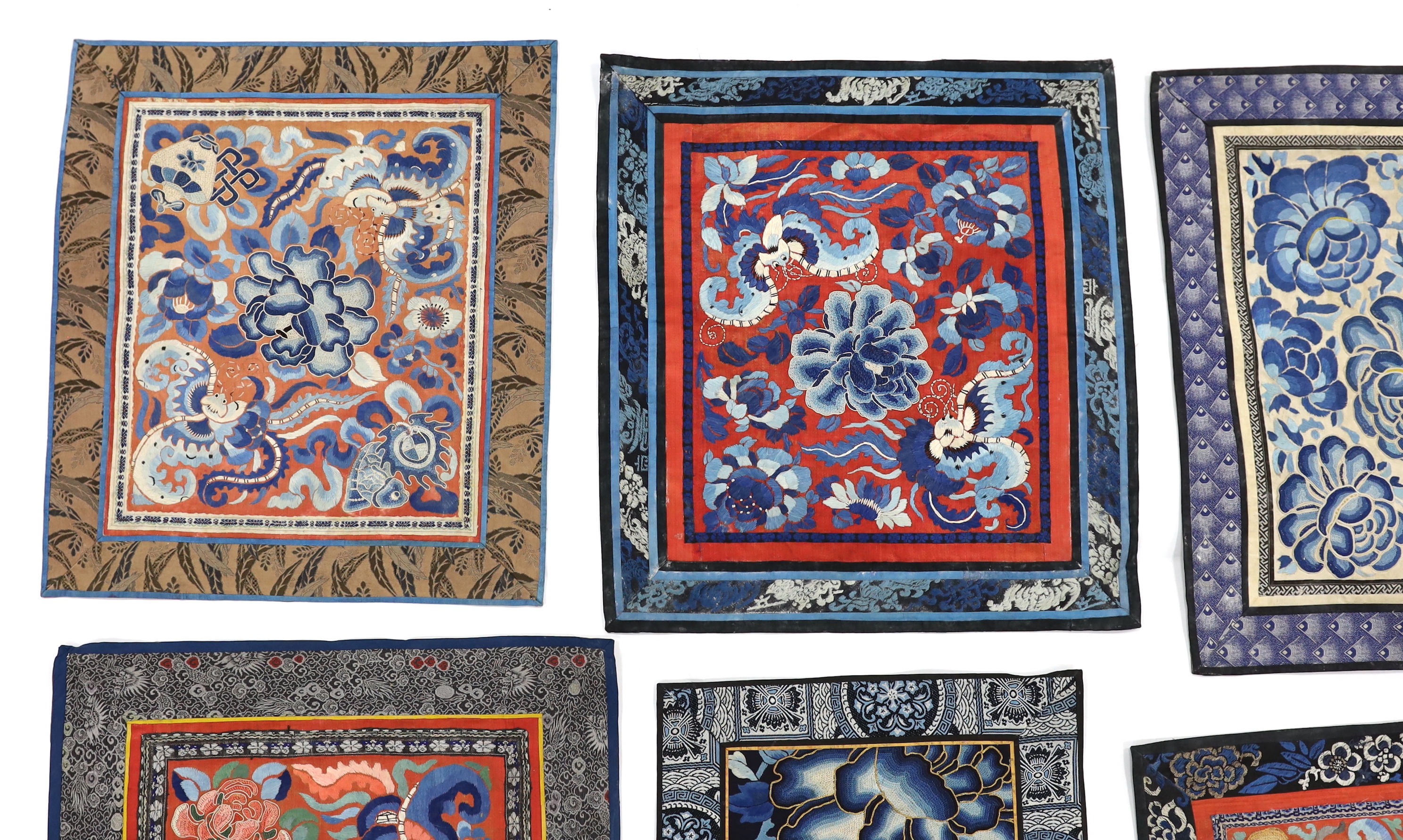 Six large Chinese silk embroidery mats with silk brocade borders, mostly embroidered flowers and butterflies in stem stitch and Beijing knot, largest 44.5cm x 37cm
